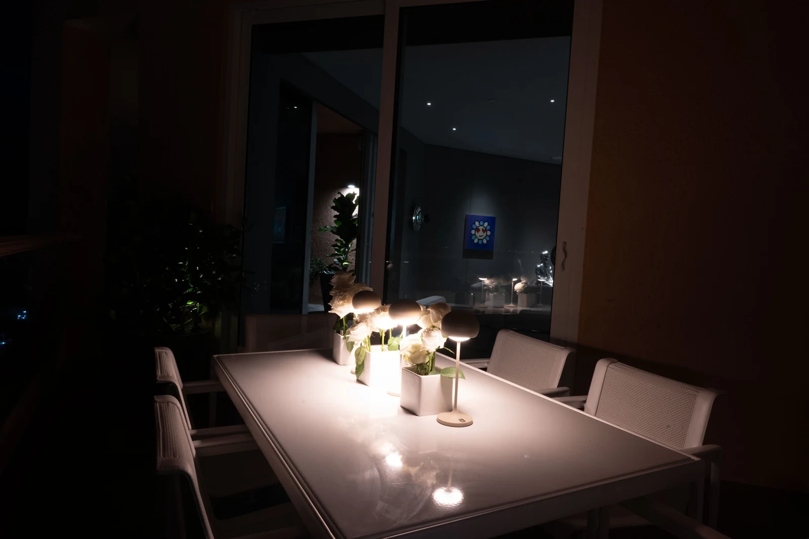 Apartment dining table illuminated by small table lamps in an evening setting