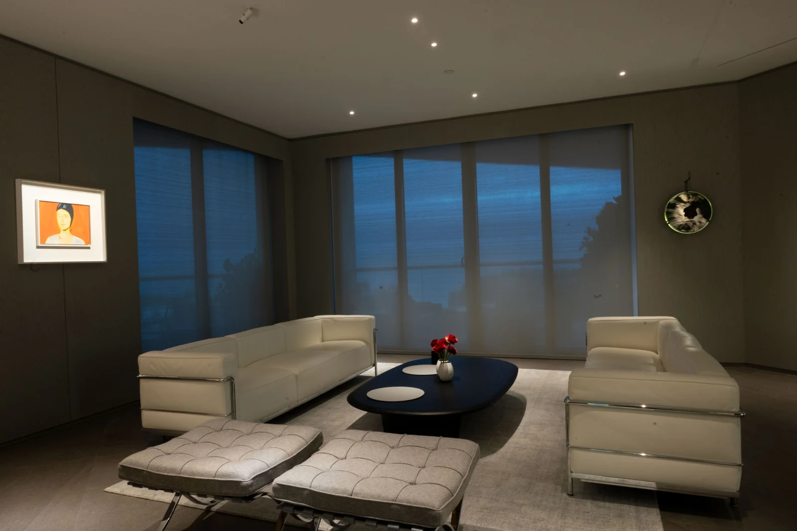 Apartment living room with recessed ceiling lights, illuminated artwork and seating arranged around a coffee table